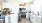 Bright modern kitchen with white cabinets, stainless steel appliances, and a group of residents enjoying a conversation at the kitchen island