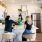 Modern kitchen with white cabinets and stainless steel appliances, featuring three residents enjoying a meal and conversation around the kitchen island.
