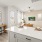 Open-concept living space with a view from the kitchen island, featuring a modern living room, natural light, and minimalist decor