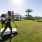 Spacious lawn game area with well-maintained grass, surrounded by palm trees, perfect for outdoor activities and gatherings