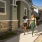 Three people standing outside modern single-story homes, having a friendly conversation on a well-maintained walkway