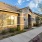 Single-story home with a stone-accented facade, large windows, and well-maintained desert landscaping under a bright blue sky